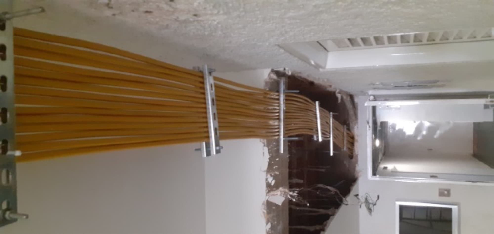 Tendido de tubería multicapa Pe-Al-Pe fijada al techo del pasillo interno de un edificio residencial