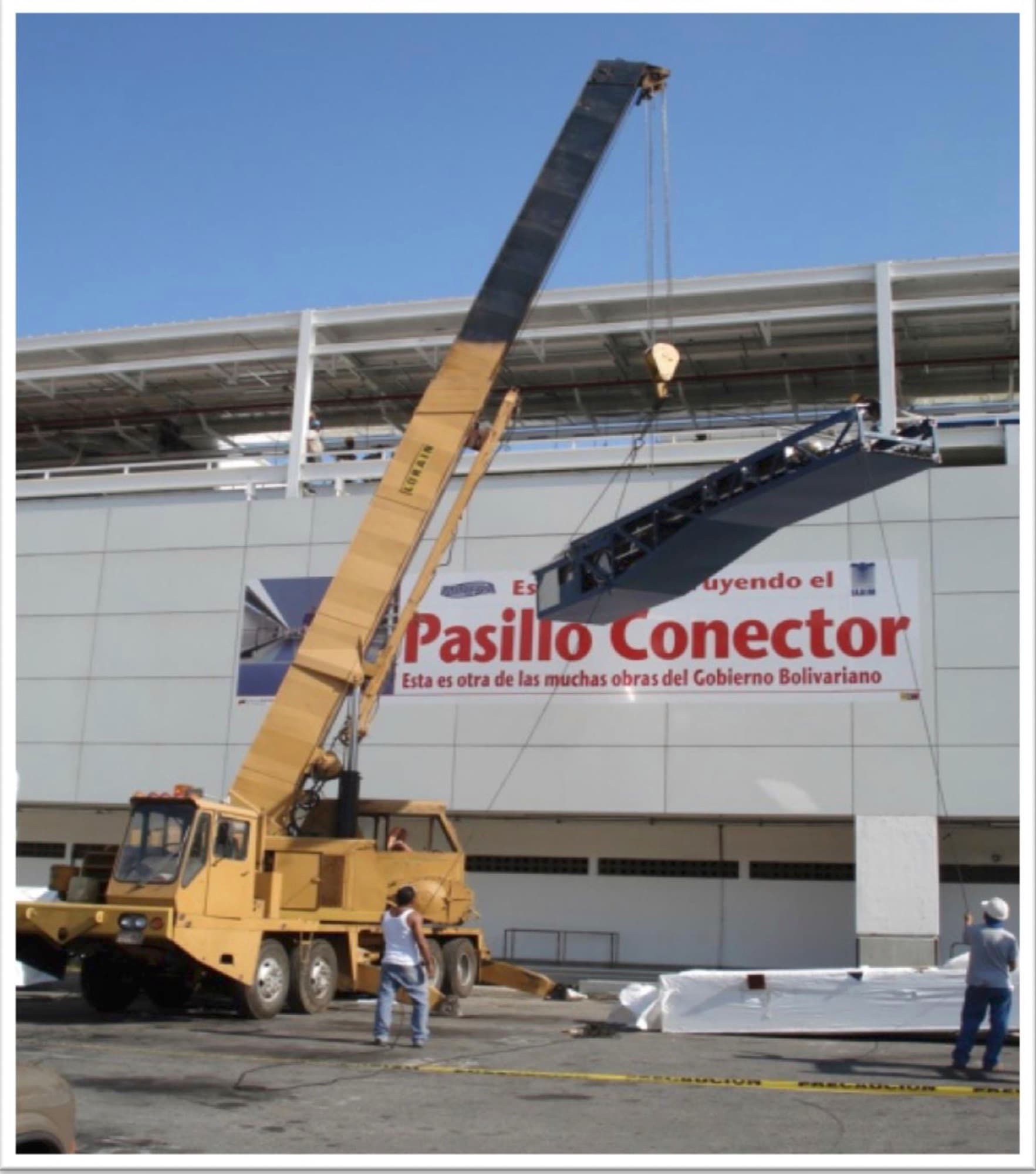 Izado de elementos estructurales con grúa durante la construcción del pasillo conector del aeropuerto de Maiquetía